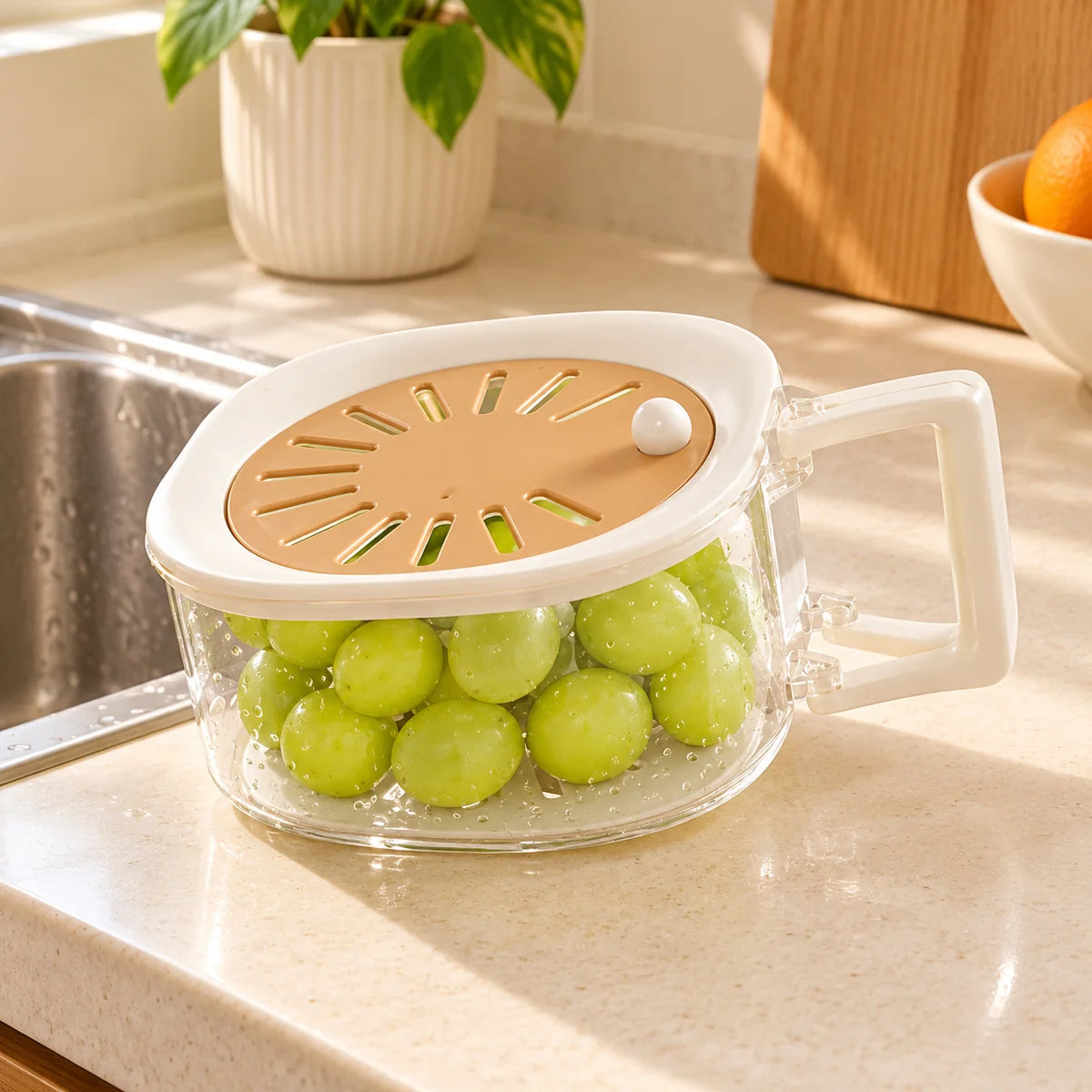 Fruit washing basket beside a kitchen sink with grapes